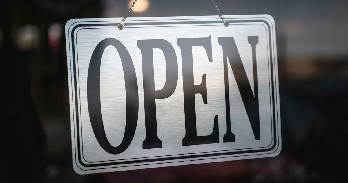 Cam dükkân kapısında zincirle asılı metal OPEN tabelası